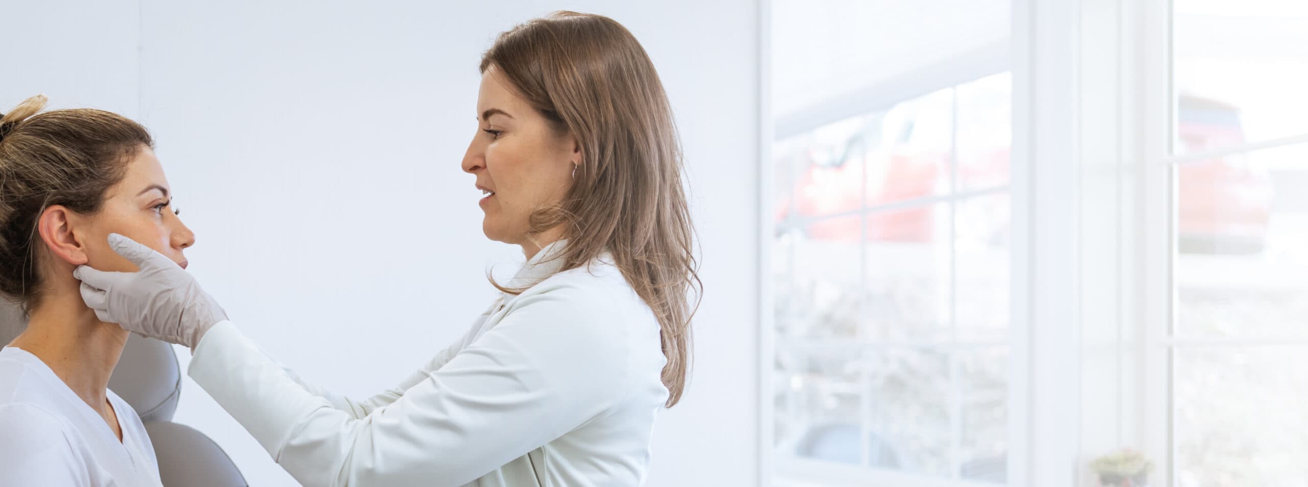 Photo of a female doctor examining a patient's face